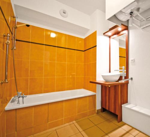 uma casa de banho com uma banheira e um lavatório em Lagrange Vacances Les Chalets d’Ax em Ax-les-Thermes