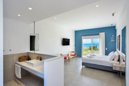 a bedroom with a bed and a bathroom with a sink at Casa Manolesos in Chorafakia