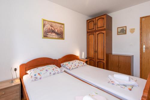 una camera con 2 letti e un armadio in legno di Apartment Valkovic a Baška