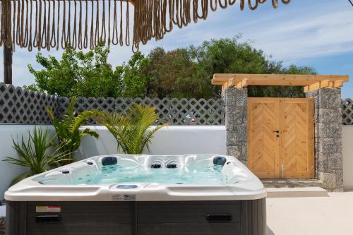 a jacuzzi tub in a yard with a gate at Aqua Villa Faliraki in Faliraki