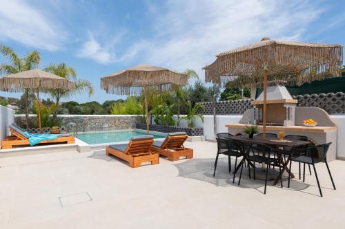 a patio with a table and chairs and a pool at Aqua Villa Faliraki in Faliraki