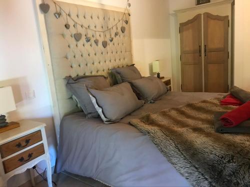 a bedroom with a large bed with a headboard at Les Authentics - Le Domaine d'Autrefois & Spa in Bolsenheim