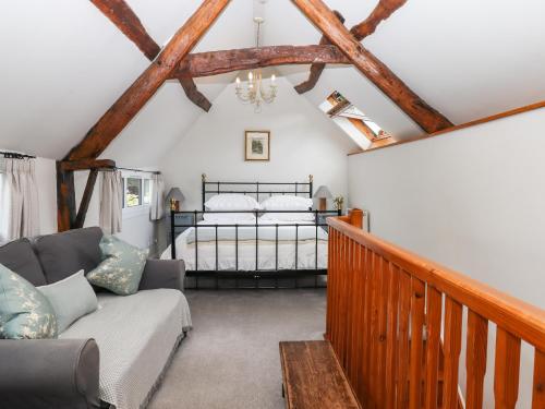 a living room with a bed and a couch at Shillings Cottage in Cullompton