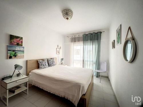 um quarto com uma cama, uma mesa e uma janela em T2 ideal para descansar e com Espanha ao lado em Vila Real de Santo António