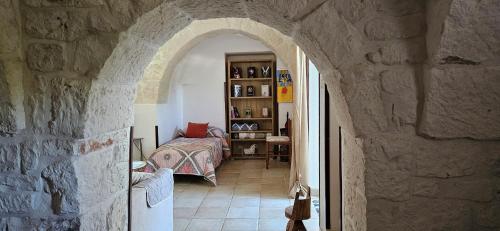 un arco en un edificio de piedra con un dormitorio en Trulli Giovanni e Angela, en Locorotondo