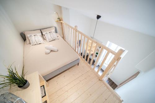 a small room with a bed and a staircase at La Maison Gratte Ciel-Appartement Paris-Jardin in Villeurbanne