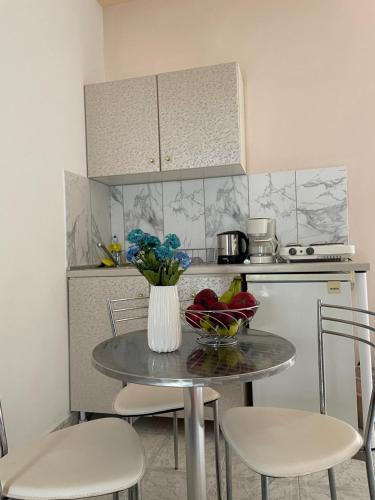 a kitchen with a table with a vase of fruit on it at SeaSide BayView in Faliraki