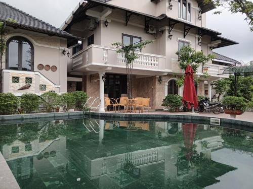 a house with a swimming pool in front of a house at IRIS HILL VILLA in Thôn Dương Xuân Hạ