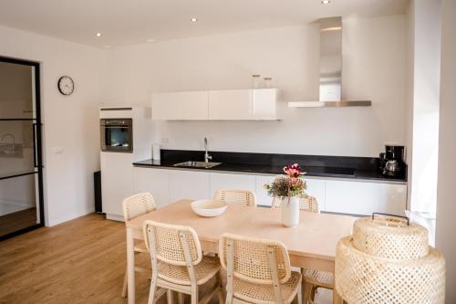 a kitchen and dining room with a table and chairs at Prachtig 6-persoons appartement in Yerseke
