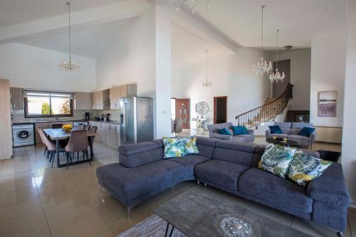 a living room with a blue couch and a kitchen at Hills View Villa in Kathikas