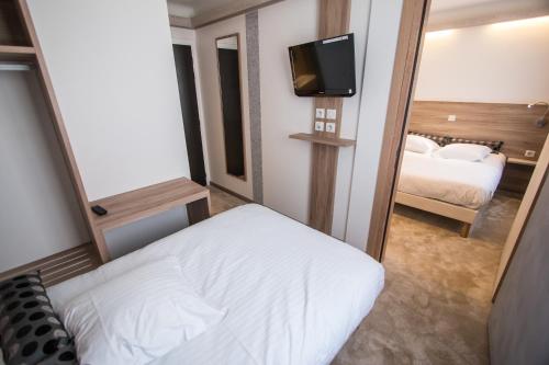a hotel room with a bed and a mirror at Hotel Les Voyageurs in Modane