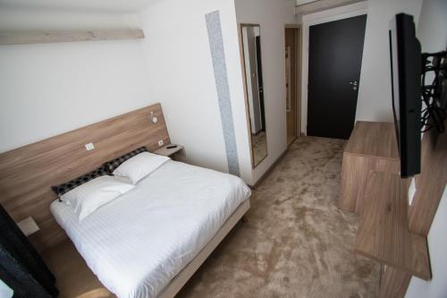 a bedroom with a bed and a flat screen tv at Hotel Les Voyageurs in Modane