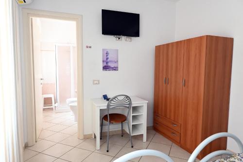 マリーナ・ディ・ビッボーナにあるAffittacamere I Gigli di Mareのデスク、壁掛けテレビが備わる客室です。