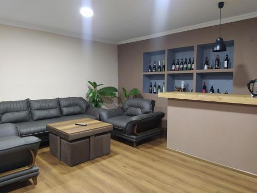 uma sala de estar com um sofá e um bar em Shanshe em Gurjaani