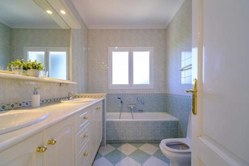 La salle de bains est pourvue d'une baignoire, d'un lavabo et de toilettes. dans l'établissement Villa La Gavina, à Jávea