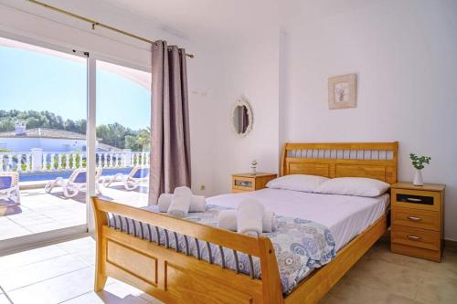 - une chambre avec un grand lit et un balcon dans l'établissement Villa La Gavina, à Jávea