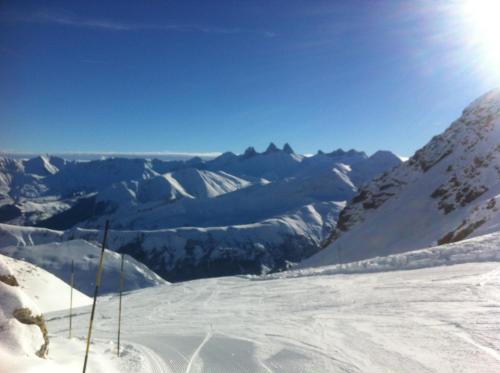 a view of a snowy mountain with the sun in the sky at Hotel Les Voyageurs in Modane