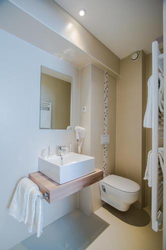 a bathroom with a sink and a toilet at Hotel Les Voyageurs in Modane