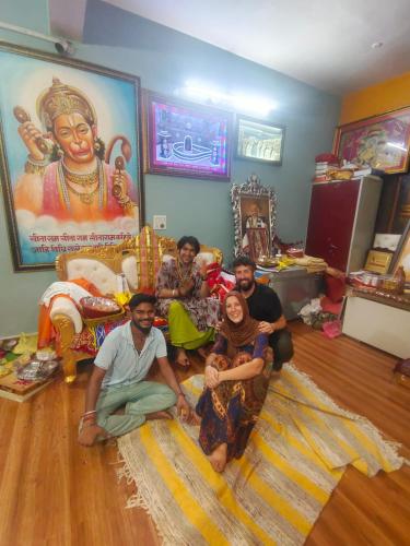 a group of people sitting on the floor in a room at Karma Hostel in Khajurāho