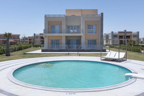 a large swimming pool in front of a building at Gewan Resort New Alamein in El Alamein