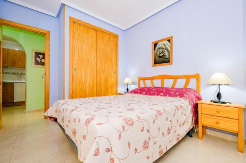 a bedroom with a bed and a table with a night stand at San Pascual ID91 in Torrevieja