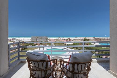 a balcony with chairs and a view of the beach at Gewan Resort New Alamein in El Alamein