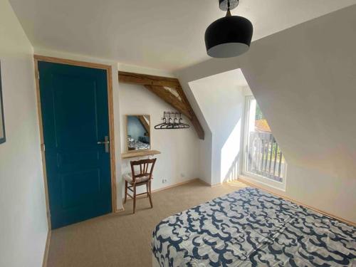 - une chambre avec une porte bleue et une chaise dans l'établissement La Grande maison du bourg, à Mareuil-sur-Cher