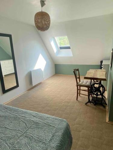une chambre avec un lit, une table et un miroir dans l'établissement La Grande maison du bourg, à Mareuil-sur-Cher
