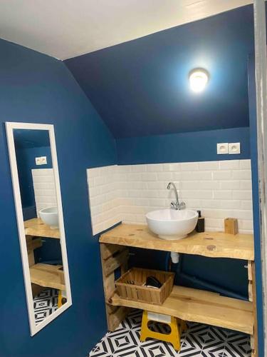 La salle de bains est pourvue d'un lavabo et d'un mur bleu. dans l'établissement La Grande maison du bourg, à Mareuil-sur-Cher