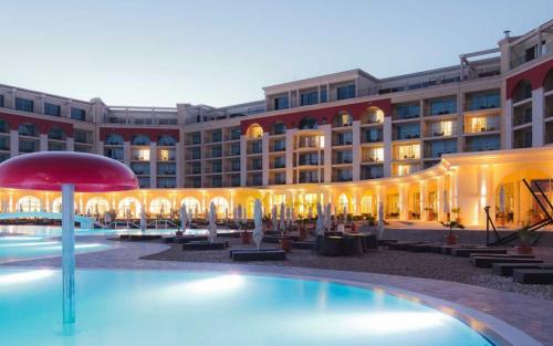ein Hotel mit einem Swimmingpool vor einem Gebäude in der Unterkunft Lighthouse Golf Resort & Spa Apartments in Baltschik