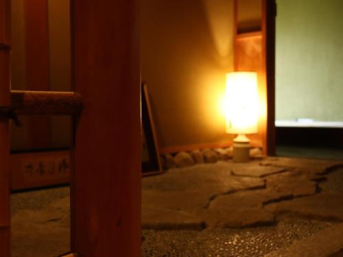 a lamp sitting in a room with a mirror at Ryokan Karasawa in Kanazawa