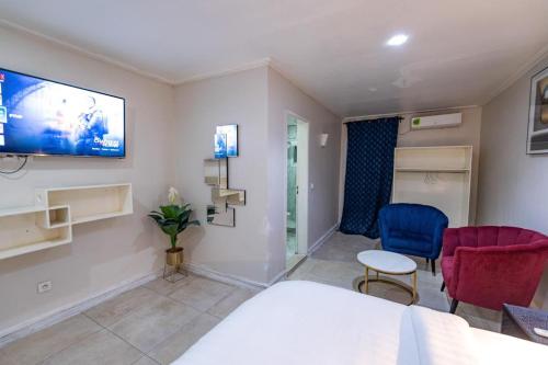 Un dormitorio con una cama y un televisor en la pared. en Villa Magnum, en Douala