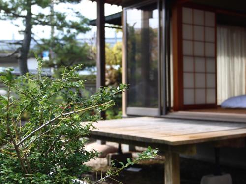 a porch of a house with a wooden table at Ryokan Karasawa in Kanazawa
