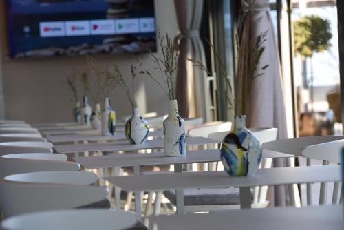 a row of white chairs with vases on them at Floria Glamping Garden in Labin