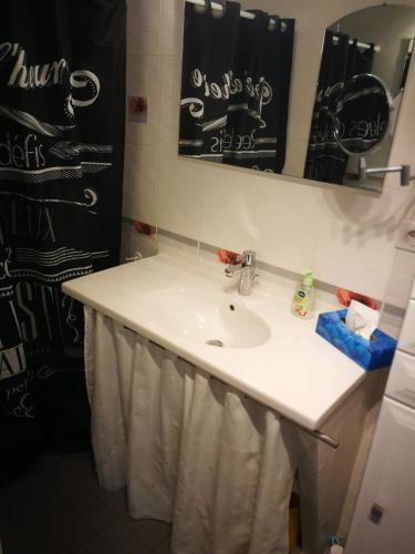 une salle de bain avec un lavabo blanc et un miroir dans l'établissement Proche du centre ville, à La Rochelle