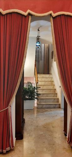 a room with a red curtain and a staircase at Sa Prenda E Oro in Ulà Tirso