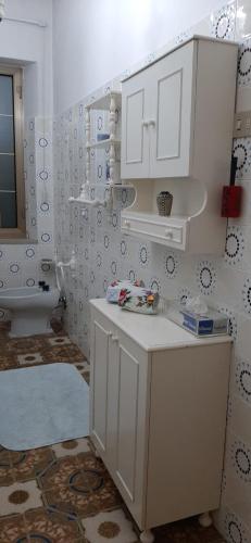 a white kitchen with a sink and a toilet at Sa Prenda E Oro in Ulà Tirso