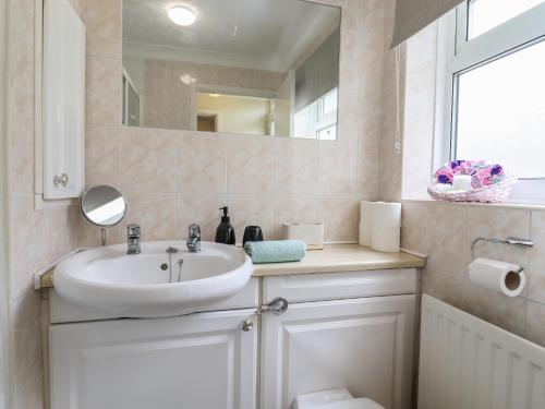 ein Bad mit einem Waschbecken und einem Spiegel in der Unterkunft 122 Morton Road in Lowestoft