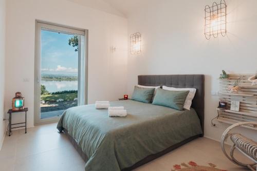 1 dormitorio con 1 cama y ventana grande en Il Gruccione Lago di Montepulciano Private Pool Stunning Views, en Binami