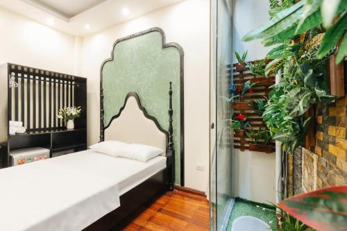 a bed in a room with plants at Sun Clover Boutique Hotel in Hanoi