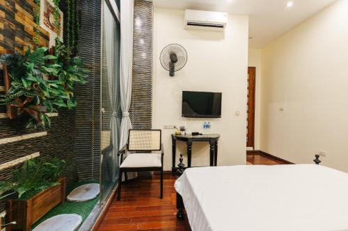a bedroom with a bed and a desk and a tv at Sun Clover Boutique Hotel in Hanoi