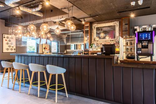 a bar with four stools in a restaurant at Premier Inn Heidelberg City Bahnstadt in Heidelberg