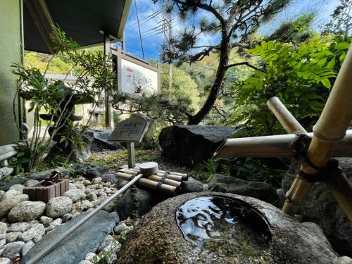 un modelo de jardín con rocas y un cartel en Katsura no Izumi, en Izunokuni