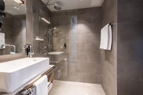 La salle de bains est pourvue d'un lavabo et d'une douche. dans l'établissement Premier Inn Heidelberg City Bahnstadt, à Heidelberg