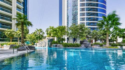a swimming pool in a city with tall buildings at Quill Residence at Paramount Towers 3 BR Creek View in Dubai