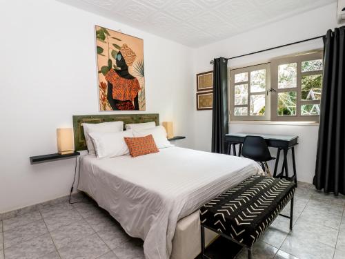 a bedroom with a large bed and a desk at Gaïa's Garden B&B Abidjan in Abidjan