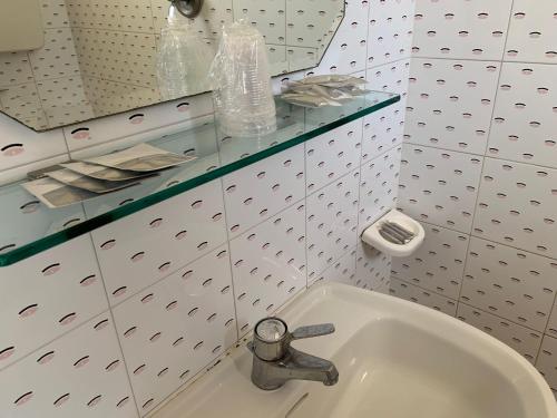 lavabo blanco en un baño con fosset en Hotel Estense en Rímini