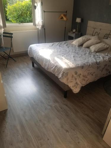 une chambre avec un grand lit et une fenêtre dans l'établissement Chambre à 10 minutes du circuit des 24H du MANS et à 5 minutes sortie Autoroute A11, à Étival-lès-Le Mans