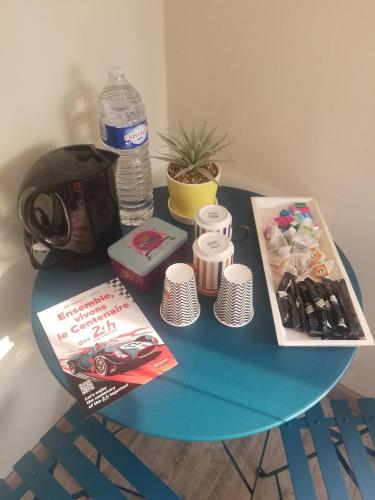 une table bleue avec un casque et une bouteille d'eau dans l'établissement Chambre à 10 minutes du circuit des 24H du MANS et à 5 minutes sortie Autoroute A11, à Étival-lès-Le Mans