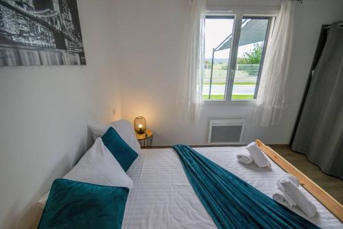 een slaapkamer met een groot wit bed en een raam bij La casa du Lac YourHostHelper in Homps